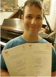 Josh Tyree with Royal School of Music Certificates for the Theory and Piano Performance tests.